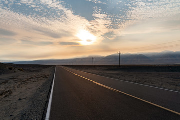 Fototapeta premium The road that can lead to anywhere - wide open spaces in the western U.S with mountains in the background