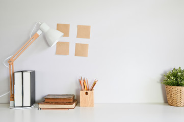 Workspace with books, pencil, sticky note and plant decoration.
