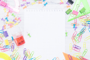 stationery objects lie around a blank white sheet, a place for an inscription
