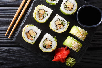 Green japanese roll with avocado, tamago omelette, sesame and cucumber closeup on a plate. horizontal top view