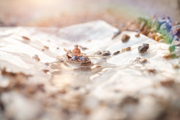 Miniature People, Miniature fishermen are fishing by boat