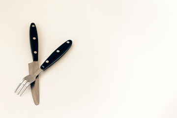 Close up knife and fork crossed, isolated on white background.