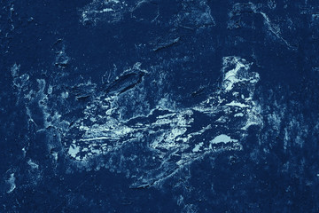 Vintage blue background. Rough painted wall of sapphire color. Imperfect plane of blue colored. Uneven old decorative toned backdrop of cyan tint. Texture of sapphirine hue. Ornamental stony surface.