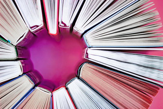 The heart of books on pink background. Top view. Love reading