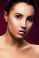 Glamour oung woman beauty face, studio headshot. Perfect skin, natural nude make-up, dark red background. Skincare health concept