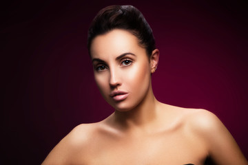 Beauty portrait of caucasian brunette woman with natural nude make-up, brown eyes, perfect skin. Copy space. Dark purple background with gradient spot