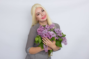 Blonde woman holding lilac flowers
