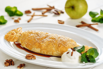 Apple Pastry Strudel Cake Stuffed Dessert Closeup. Austrian Puff Pie with Vanila and Sesame Mint Leaf on White Plate. Bakery Cook for Birthday Breakfast. Crust Homemade Apfelstrudel Gourmet Ice Cream