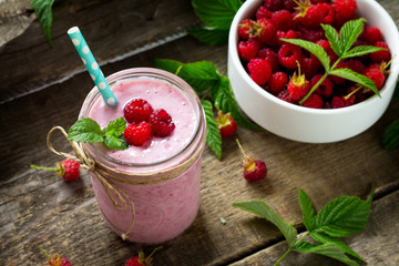 Raspberry fruit Yogurt smoothie or milk shake in glass jar on a wooden rustic table. Natural detox, fruit dessert, healthy dieting concept.