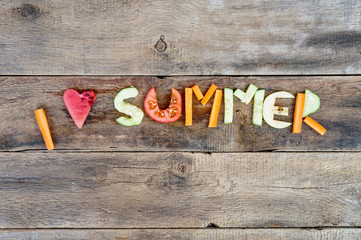 I love summer made fom frruits and vegetables cut out over wooden background