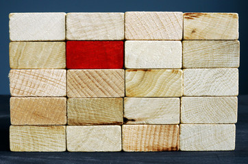 Stand out from the crowd concept. Red wooden block and whites.