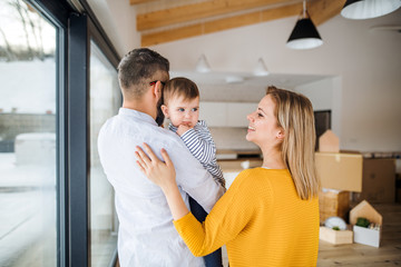 A young family with a toddler girl moving in new home.