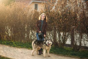 Beautiful young girl walk with husky dog. Happy female with her pet