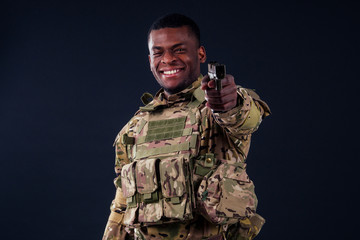 american man in camouflage suit aiming with a pistol