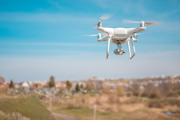 Close up on white drone camera. Drone quadcopter in flight