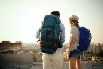 Happy young couple of travellers holding map and having fun