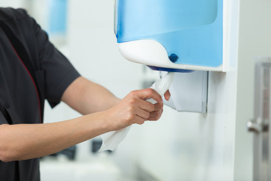 hands usings a tissue dispenser