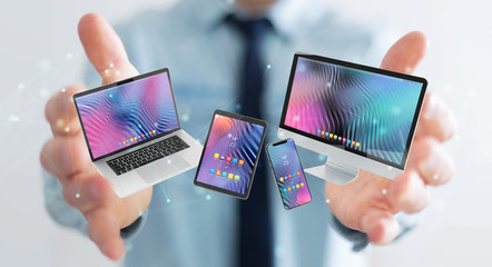 Businessman connecting modern smartphone tablet laptop and computer 3D rendering