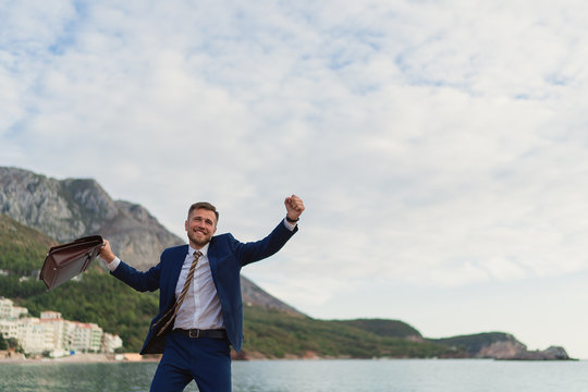 Happy businessman dancing on the beach - Powered by Adobe