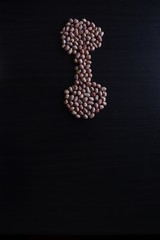 set of raw peanuts making design on a dark wooden table