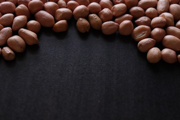 set of raw peanuts making design on a dark wooden table