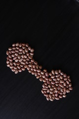 set of raw peanuts making design on a dark wooden table