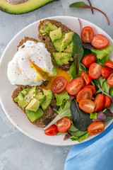 Healthy Breakfast with avocado toasts, poached egg and salad, top view, close up