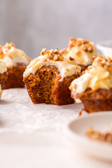 Carrot cupcakes with cream cheese frosting and caramel topping with pecans, close up, selective focus