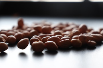 set of raw peanuts making design on a dark wooden table