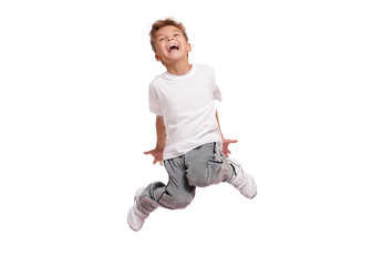Adorable little boy smiling and jumping, isolated on white background. Shooting in the studio.