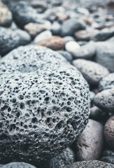 Close up picture of a volcanic rock on a beach, selective focus, color toning applied.