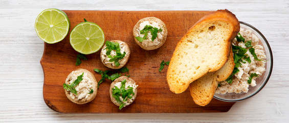 Mushroom and chicken puree with lime and toasts on rustic wooden board, overhead view. White wooden background. Flat lay, top view.