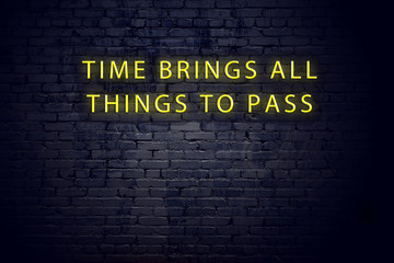 Neon sign with positive wise motivational quote against brick wall
