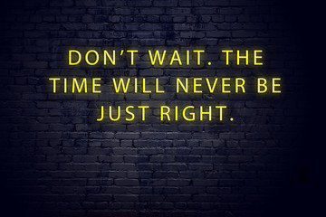 Neon sign with positive wise motivational quote against brick wall