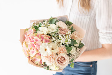 Delicate bouquet of mixed flowers in womans hands. the work of the florist at a flower shop. Delicate Pastel color. Fresh cut flower. White and pink color