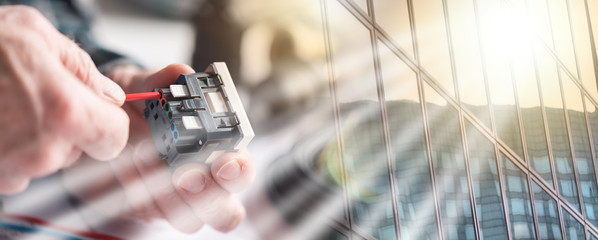 Electrician connecting a wire into a power socket, light effect. multiple exposure