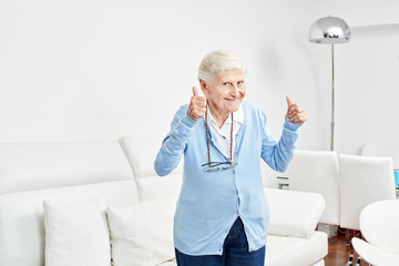 Optimistische alte Frau hält die Daumen hoch