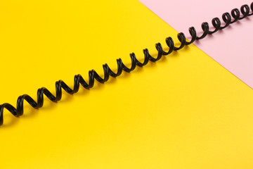 black curl cable socket on pastel colour background