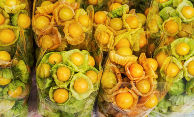 Group of fresh cape gooseberry in plastic bags on stall in a Asia market