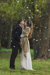 Wedding couple in rustic style in love in the pine wood posing  in sunbeams