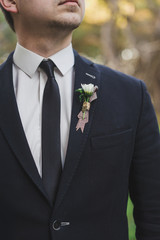 A rustic boutonniere on the suit closeup