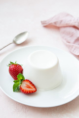Panna cotta, traditional italian dessert, served with fresh strawberry and mint