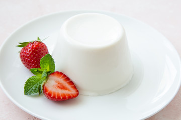 Panna cotta, traditional italian dessert, served with fresh strawberry and mint
