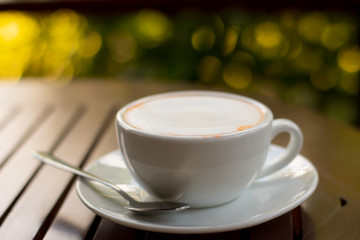 Cup of tea on wooden table on bokeh background. 