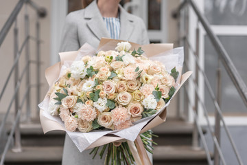 Large Beautiful bouquet of mixed flowers in woman hand. Pink and white color. the work of the florist at a flower shop. Delicate Pastel color. Fresh cut flower.