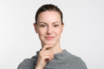 face of a young woman with hand at her chin