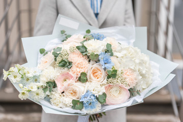 Nice bouquet of mixed flowers in woman hand. Pink and white color. the work of the florist at a flower shop. Delicate Pastel color. Fresh cut flower.