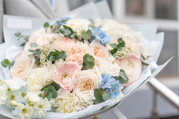 Nice bouquet of mixed flowers in woman hand. Pink and white color. the work of the florist at a flower shop. Delicate Pastel color. Fresh cut flower.