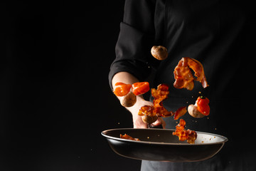 Cooking bacon on a skillet with garlic, hot pepper and mushroom, on a black background, menu, and...