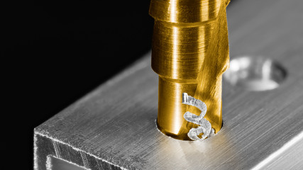Step drill bit. Twisted swarf detail. Making hole in aluminum profile. Unibit closeup. Drilling of...